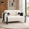 Modern two-seater sofa with cream upholstery and black accents Cream modern sofa with black legs for contemporary interiors Two-seater sofa with textured cream upholstery and black side detailing Modern sofa furniture by Global Star Furniture in Ghaziabad Contemporary cream sofa with black cylindrical legs and cushions