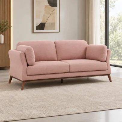 Modern pink fabric sofa with wooden legs Blush pink upholstered sofa with cushions Modern living room sofa with rounded armrests Contemporary pink fabric sofa by Global Star Furniture Pink sofa manufacturer in Ghaziabad with wooden legs